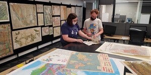 A student and staff member inspecting a map in the Map and Geospatial Hub.