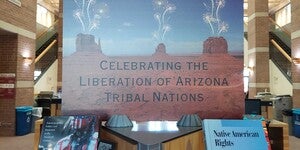 Photo featuring title of display with two books from Fletcher Library's Open Stacks on either side. Display sign designed by Ashley Davis (Navajo).