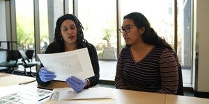 A student and archivist reviewing archival materials together.