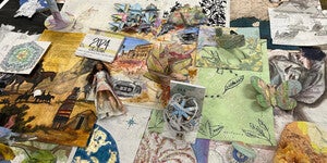 Illustrated artwork and drawings on cartographic materials displayed on a table