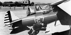 Pilot cadets in flight gear stand next to bi-planes in preparation for flight training at Thunderbird Field No. 1.