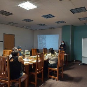 Pictured is Kayla Shaggy speaking to the audience in the Labriola Center at West Campus. The room is dimly lit and a projector lights up the wall. The slide says, "How Did I Get Here."