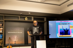 Ruben Cu:k ba’ak reading in front of a podium