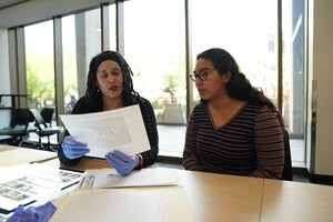 A student and archivist reviewing archival materials together.