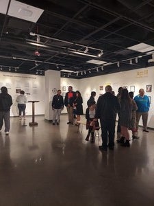 Group of people waiting in a room and viewing printed archival material.