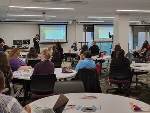 Labriola's Director giving opening remarks at the Office of Indian Education Symposium in front of a large audience of people.