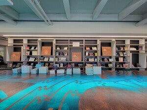 Variety of books on display with orange signs with questions.