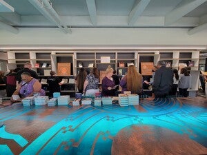 Large group of people viewing books 