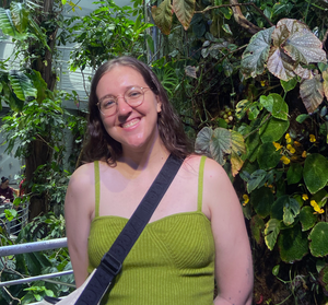 female standing in front of  foliage