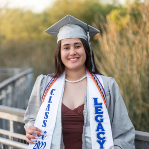 Library Aide Mafi Pamaka in silver graduation cap and gown