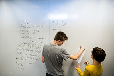 students use a whiteboard in a library study room