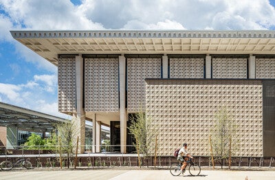 Cyclist riding by Hayden Library on ASU Tempe campus