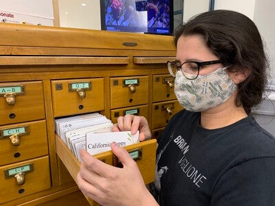 ASU library specialist Christina Sullivan next to the card catalog