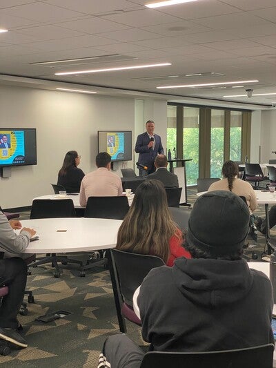 Bryan Newland, Assistant Secretary of the Interior for Indian Affairs speaking to a crowd of people in room 236 in Hayden Library