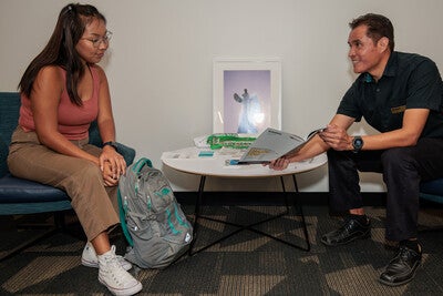 Two people sitting at a table looking at materials